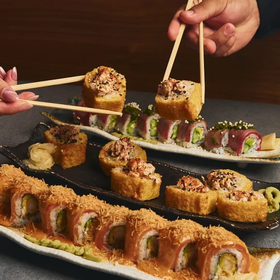 Nikkei sushi rolls shared at the table